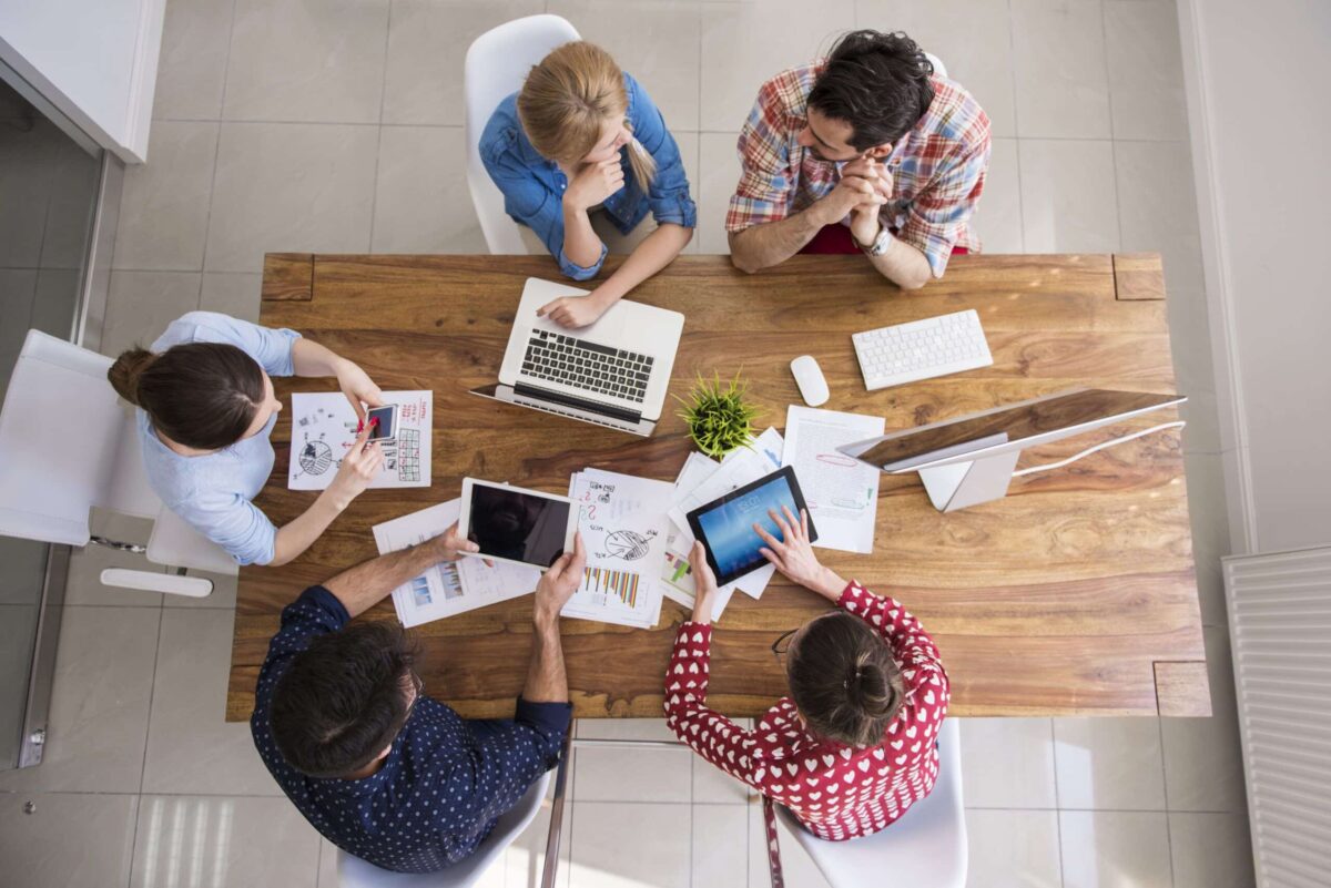 vista superior equipo companeros trabajo trabajando oficina scaled 1 Vivienda Inversa (Almagro Capital) + ROI&CO: Desarrollo de 0 a 100 para mejorar la captación de leads a través de Zoho CRM